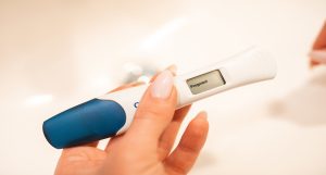 woman holds pregnancy test indicating positive result