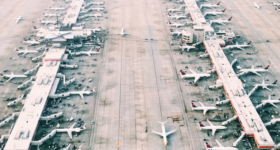 Row of planes parked on tarmac.