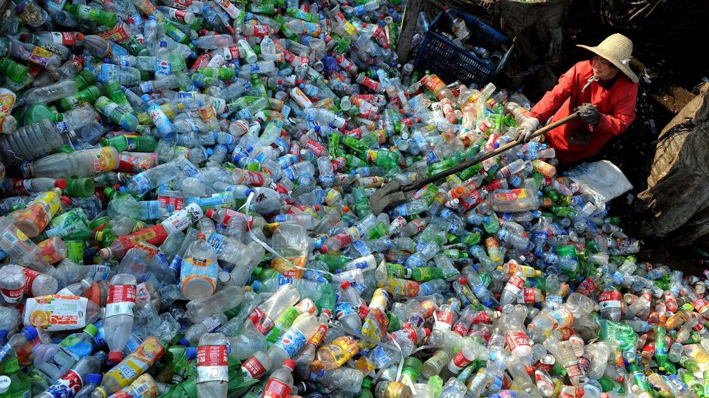 A worker piles up plastic bottles collected at a recycling centre in Hefei, China's Anhui province.