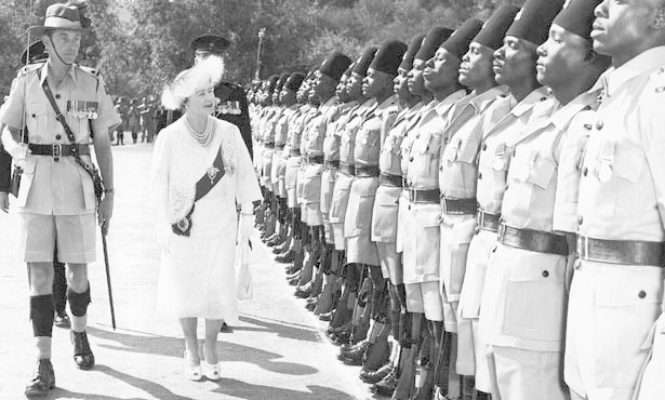 Queen Elizabeth, accompanied by the guard commander Major R. Aikenhead, inspects a guard of honour at the great Indaba in the Matotos Hills, near Bulawayo, Rhodesia on July 8, 1957.