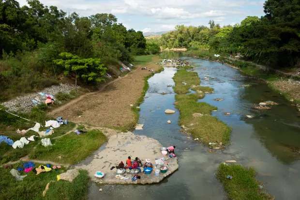 Women wash laundry along the Meille River, a tributary to the Artibonite River. This is the longest waterway in Haiti, which carried cholera through the country. 
